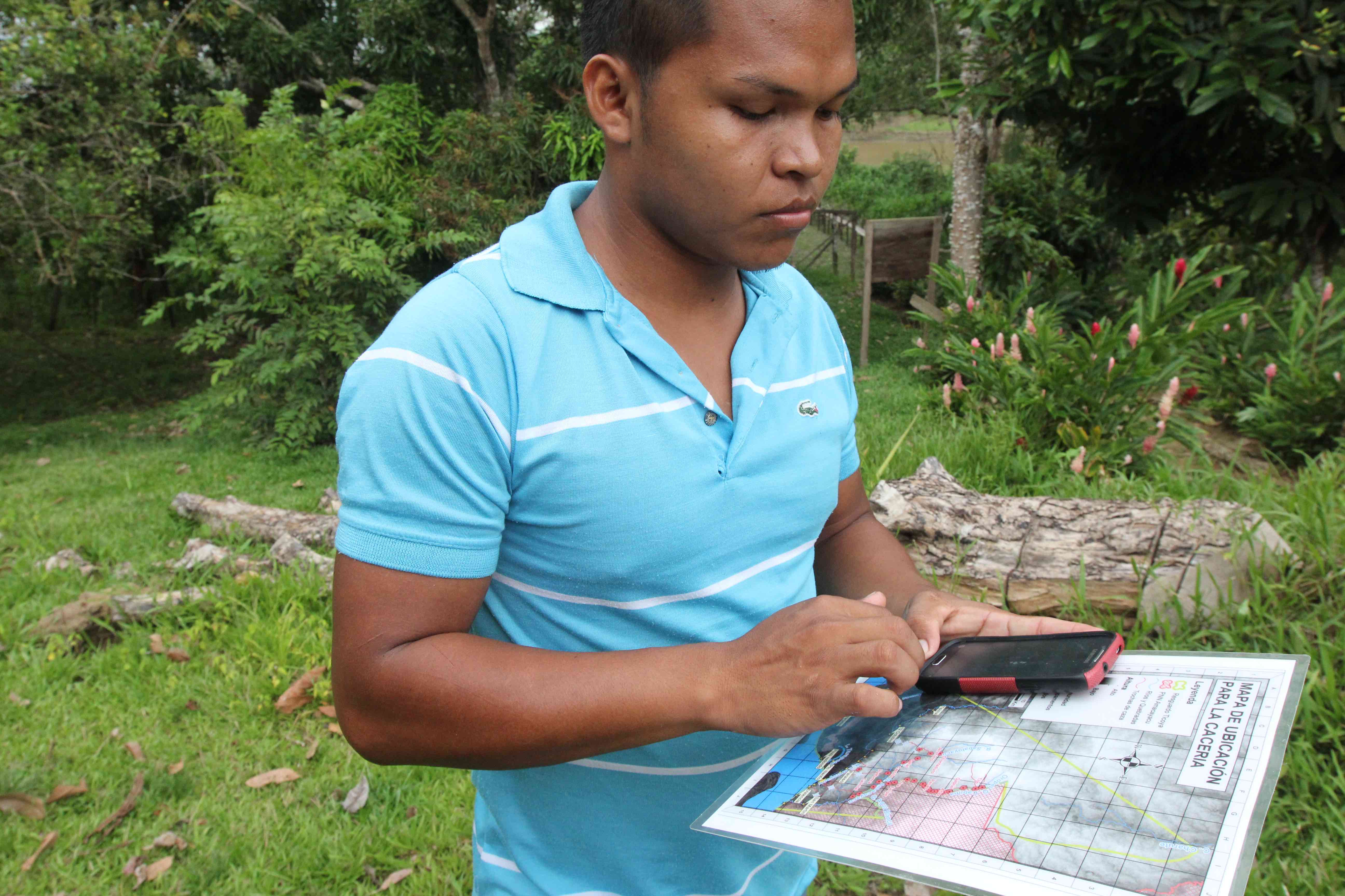 Tikuna hunter Milton Pinto of Puerto Nariño, Colombia, uses a cell phone app to monitor his hunting. Copyright: Barbara Fraser.